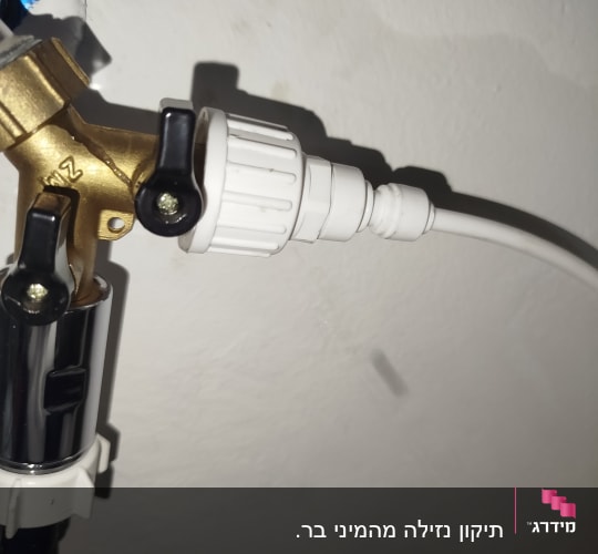 חיבור צינור למערכת מים על קיר